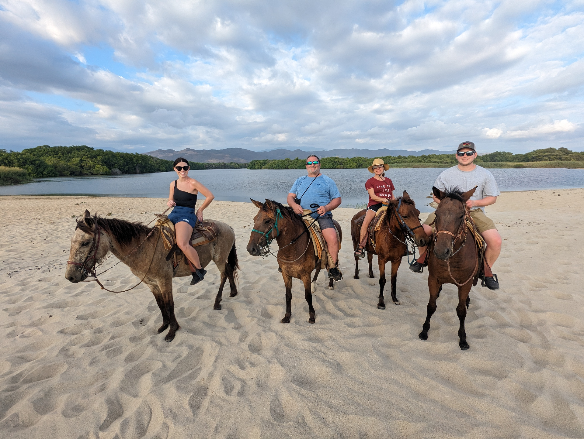 Group horseback riding on beach in Puerto Escondido