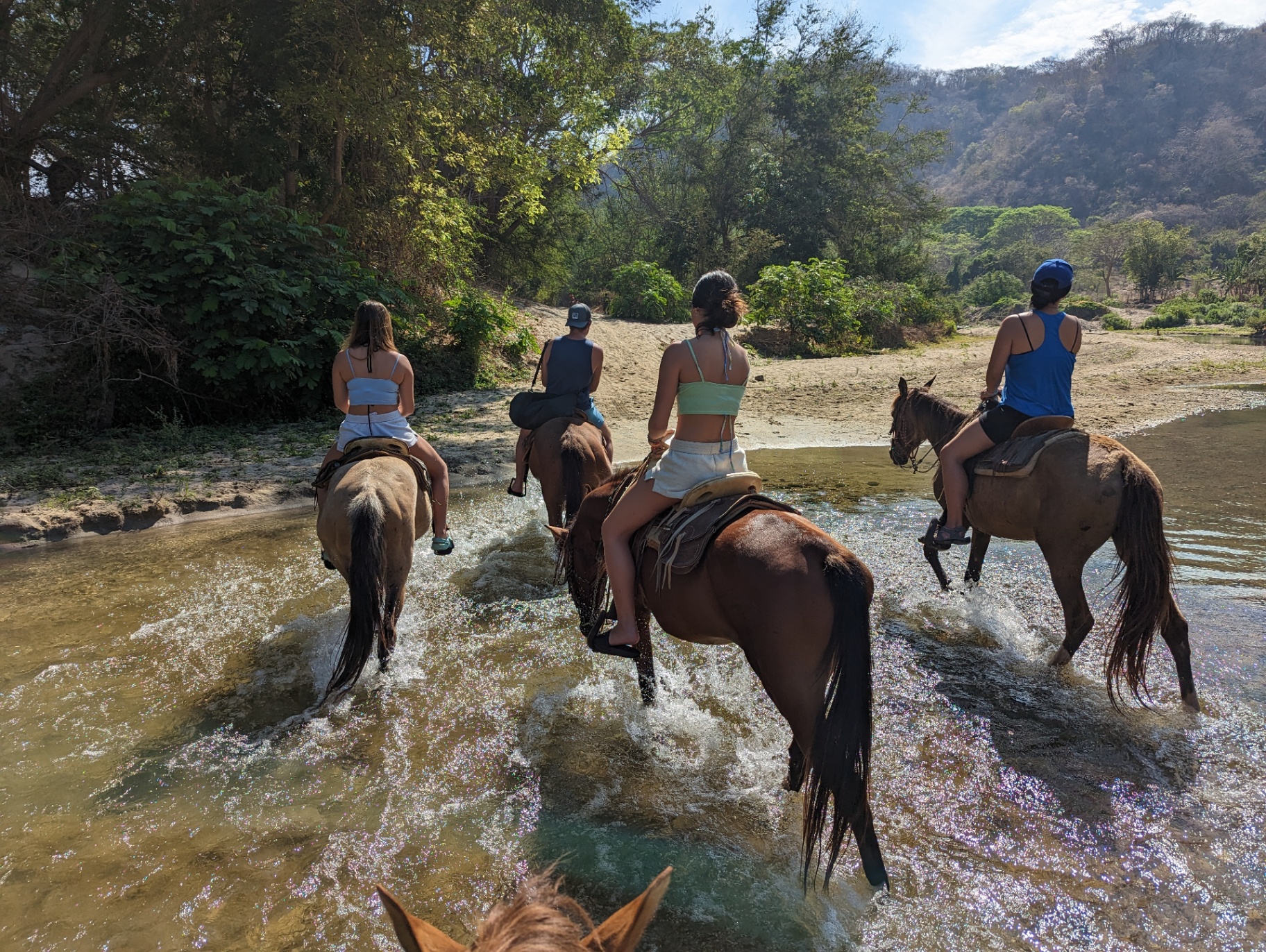 Horseback riders crossing river in Puerto Escondido